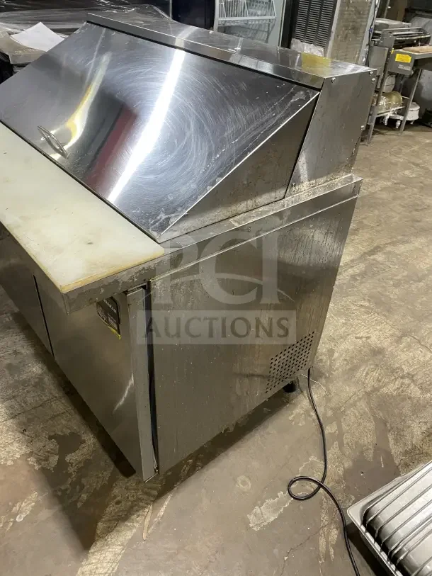 Commercial stainless steel 2-door refrigerated prep station table with cutting board, Model HKN-SPMT48R2E, on casters.