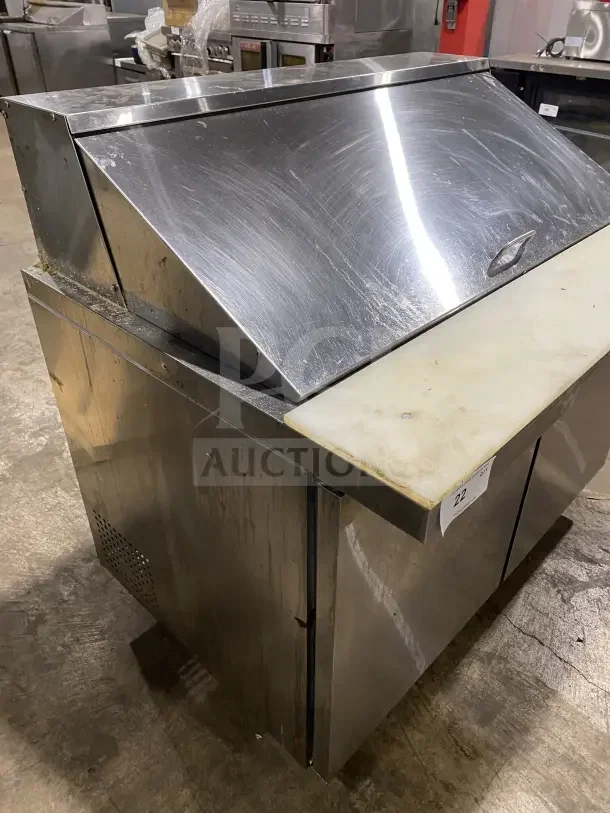 Commercial stainless steel 2-door refrigerated prep station table with cutting board. Model: HKN-SPMT48R2E, on casters.