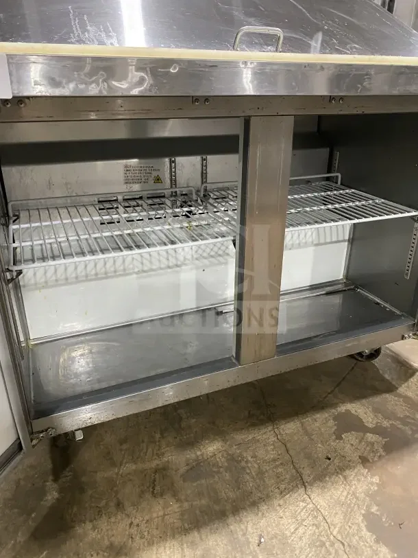 Commercial stainless steel 2-door refrigerated prep station, model HKN-SPMT48R2E, with cutting board, on casters. Used condition.
