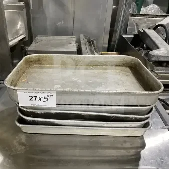 Commercial stainless steel baking trays, stack of five. Used condition with visible wear. Auction label: "27 x 5 QTY".