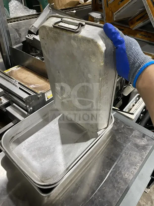 Commercial stainless steel baking tray, stackable; showing signs of use; durable design ideal for heavy-duty baking.