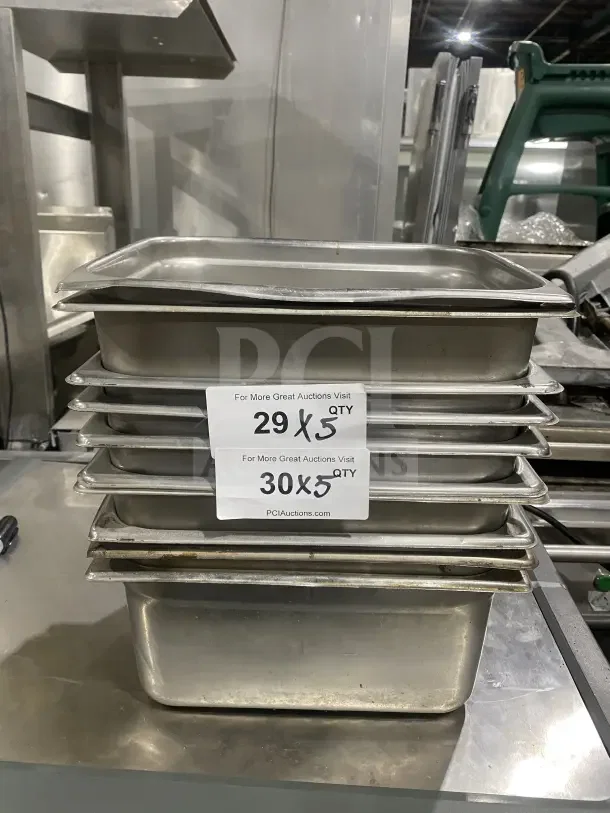 Commercial stainless steel prep trays, stack of five, used condition, ideal for sauce or salad prep in kitchens.