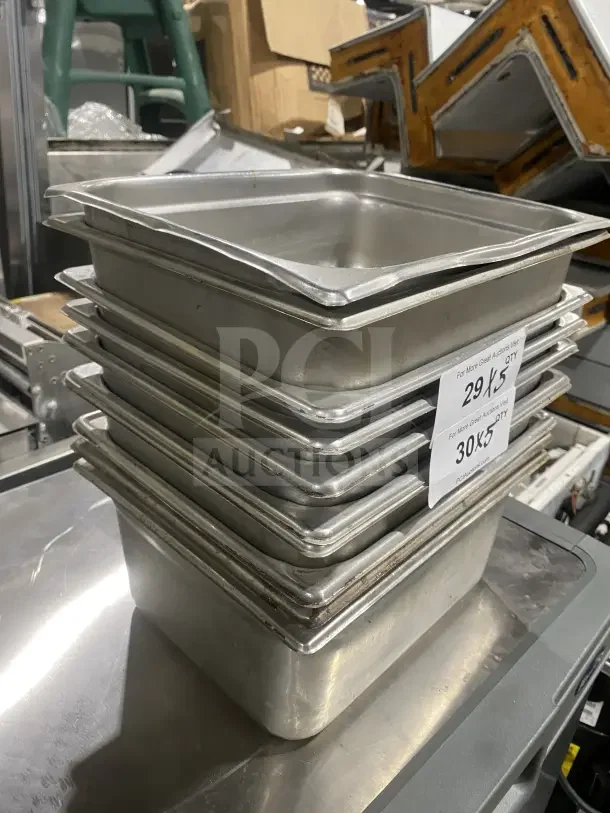 Stacked commercial stainless steel sauce or salad prep trays. Lightly used, durable construction. Tag indicates auction lot 30X5.