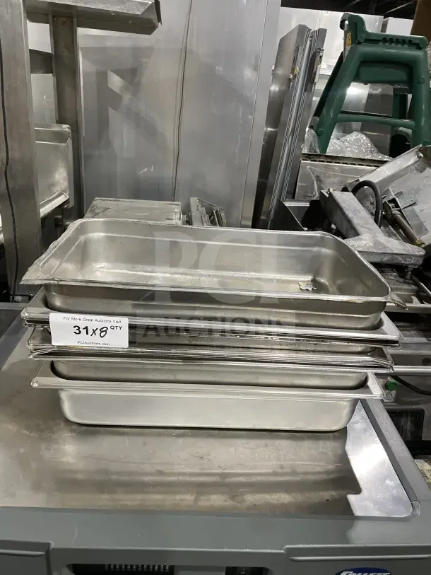 Stack of commercial stainless steel baking trays. Includes 31 units. Durable and ideal for baking.