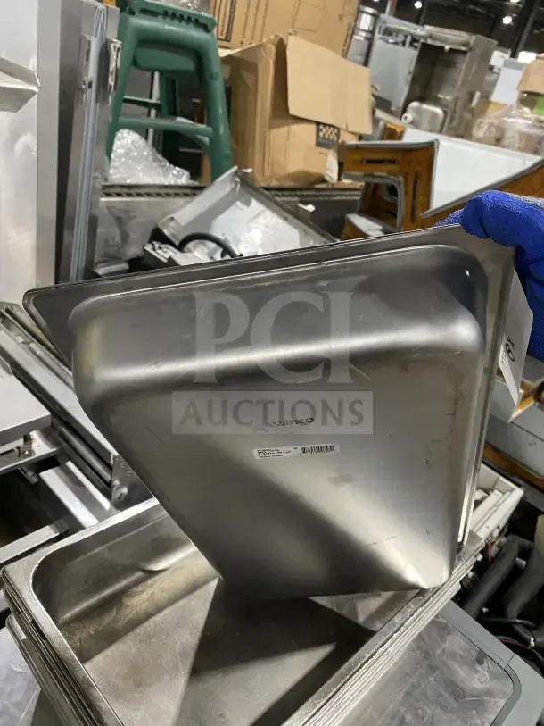 Commercial stainless steel baking tray by Winco, visible label, durable, stack of trays, worn but functional condition.