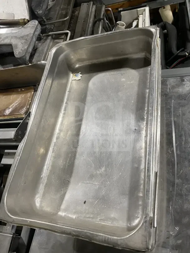 Commercial stainless steel baking tray in fair condition, rectangular with visible wear, stackable design.
