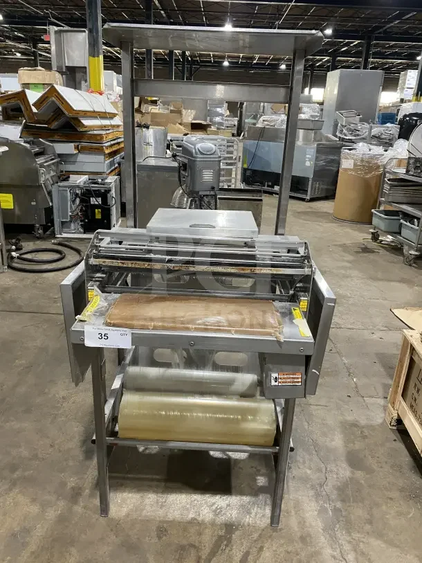 Good Nature commercial stainless steel wrapping station with casters. Used condition, equipped with packaging rolls.