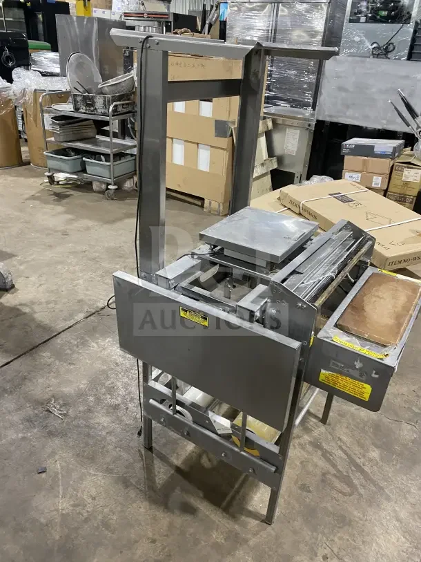 Good Nature stainless steel floor-model wrapping station on casters, excellent condition, visible safety and operational labels.