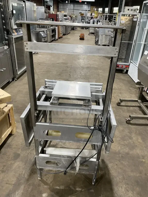 Good Nature stainless steel floor-model wrapping station on casters, used condition, includes metal frame and electrical cord.