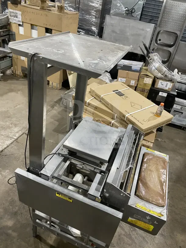 Good Nature stainless steel floor-model wrapping station, on casters, sturdy build, visible control labels, used condition.
