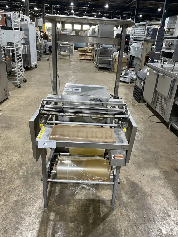 Commercial stainless steel wrapping station on casters, Model 0662, SN 0440300007, 120V, excellent condition, features built-in cutter.