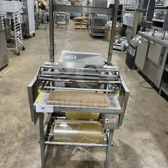 Commercial stainless steel wrapping station on casters, Model 0662, SN 0440300007, 120V, excellent condition, features built-in cutter.