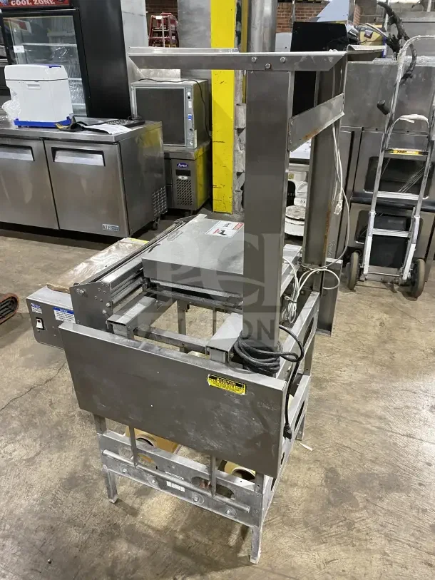Commercial stainless steel floor-model wrapping station, Model 0662, on casters. Includes electrical cord. Serial number: 0440300007.
