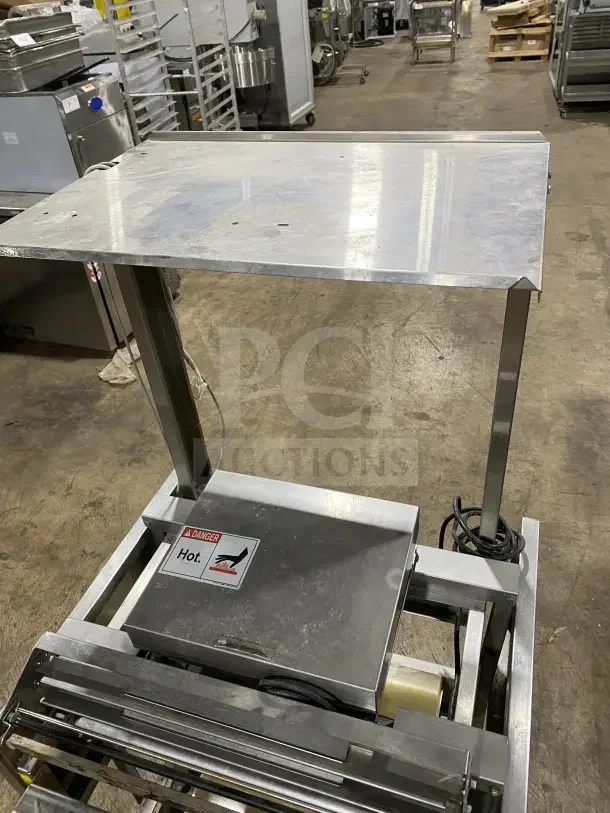 Commercial stainless steel floor-model wrapping station, Model 0662, on casters. Features "Hot" warning label. 120V, on legs.