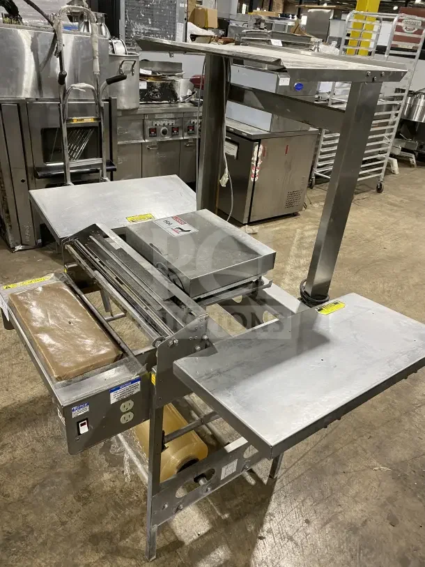 Commercial stainless steel floor-model wrapping station, Model 0662, on casters with multiple shelves, 120V, in good condition.