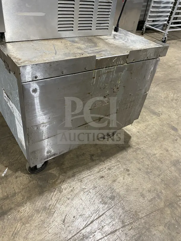 Atosa commercial stainless steel chef base refrigerator, model MGF8448GR, on casters. Visible wear on surface.