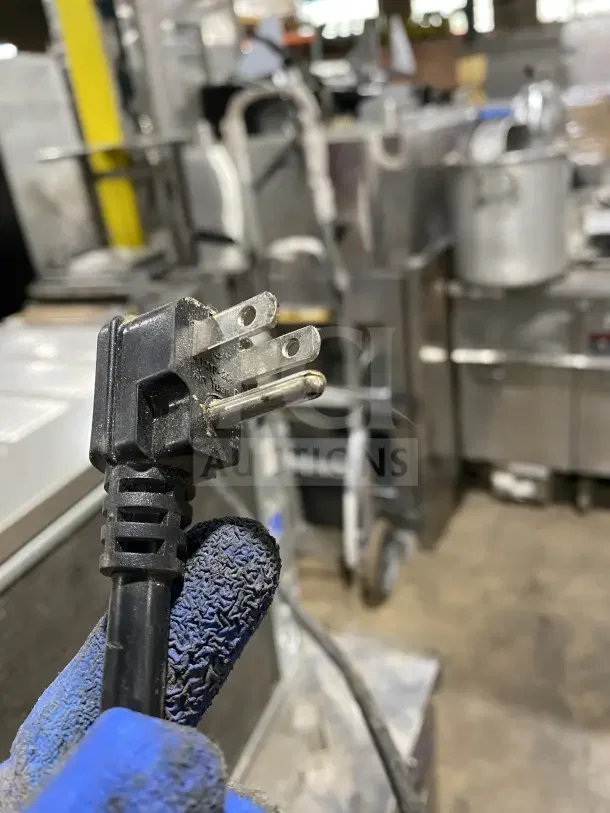 Atosa MGF8448GR electric chef base refrigerator plug, showing three-prong design, part of heavy-duty stainless steel unit on casters.