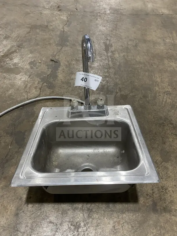 Commercial stainless steel drop-in hand sink with faucet, slightly worn. Number 40 tag visible on faucet.