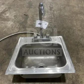 Commercial stainless steel drop-in hand sink with faucet, slightly worn. Number 40 tag visible on faucet.