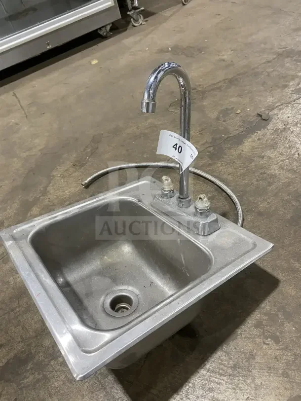 Commercial stainless steel drop-in hand sink with faucet, lightly used. Includes flexible water line and labeled auction tag.