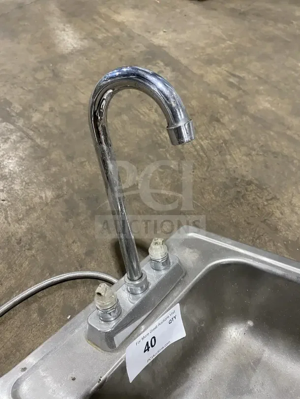 Commercial stainless steel drop-in hand sink with faucet. Visible label reads "40 PCI Auctions." Excellent condition.