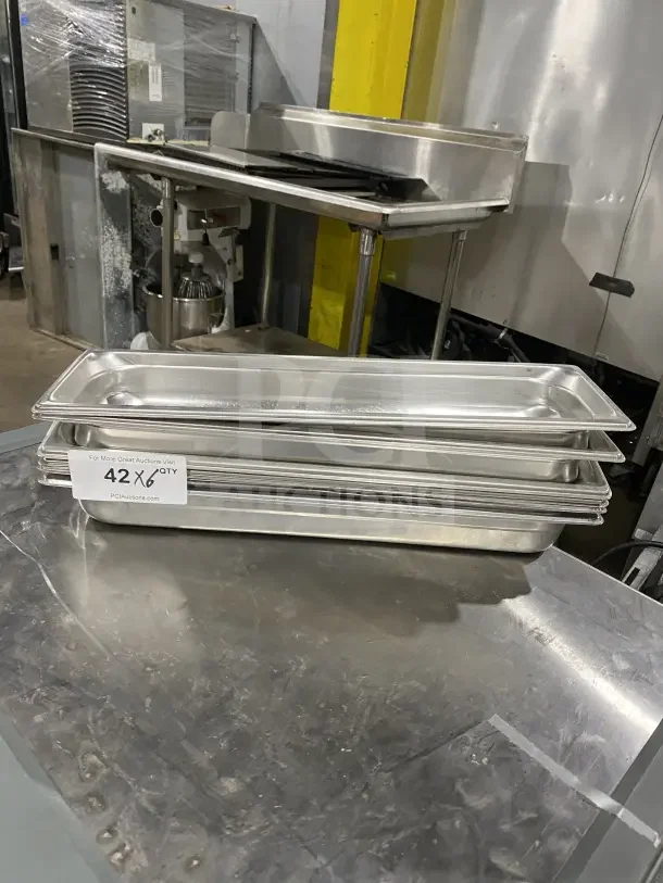 Commercial stainless steel full-size hotel pans stack. Slightly used, set of 6. Tag reads "42 x 6 Qty."