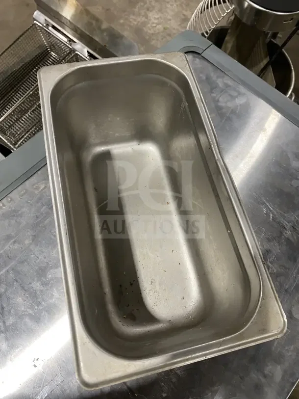 Winco stainless steel half-size hotel pan, model SPJL306, in used condition, visible wear on interior.