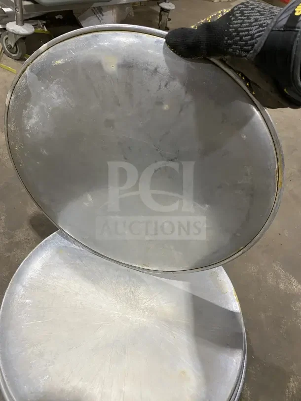 Commercial round aluminum pizza pans, lightly used, stack of seven. Durable, ideal for baking and commercial use.