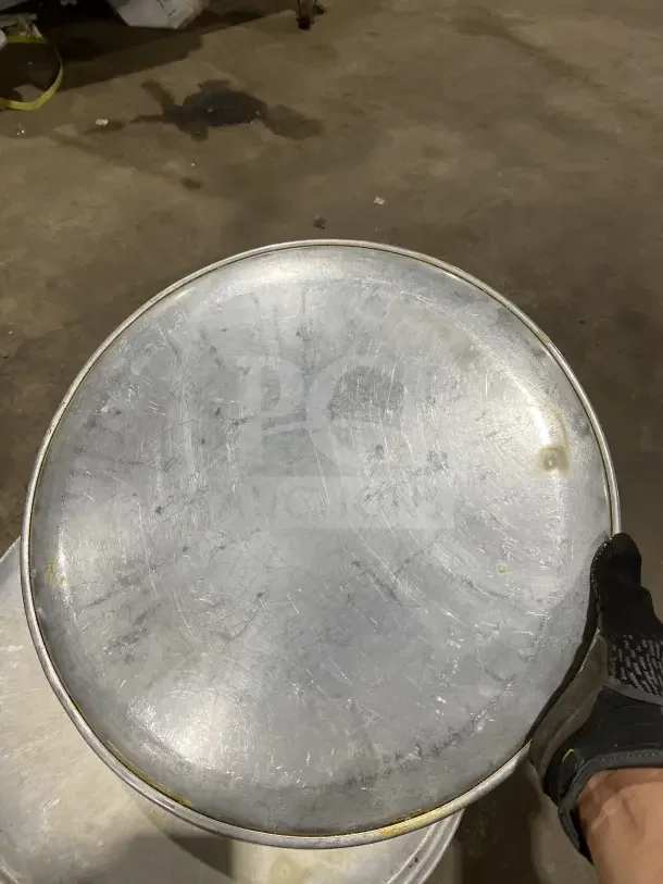 Commercial round aluminum pizza pan, visible wear, durable, ideal for restaurants. Auction offers seven pans per bid.