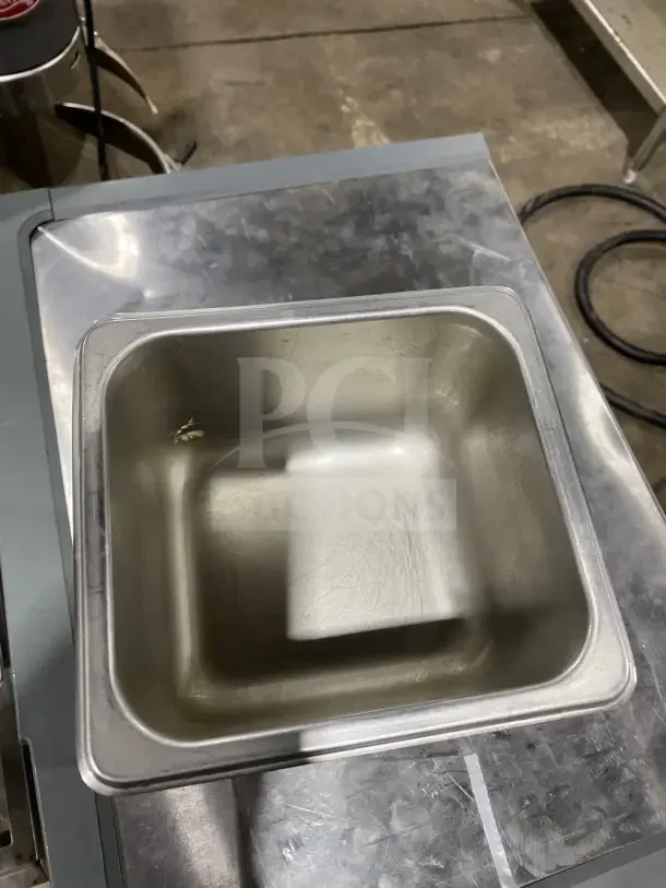 Commercial stainless steel sixth-size food pan, slightly used, measuring 13" by your bid, ideal for hotel or restaurant use.