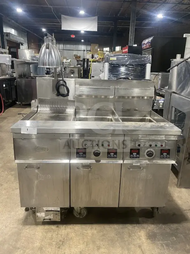 Keating 14TSSI stainless steel dual fryer, natural gas, instant recovery, heating element, back splash, on casters, model and serial number visible.