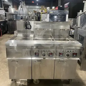 Keating 14TSSI stainless steel dual fryer, natural gas, instant recovery, heating element, back splash, on casters, model and serial number visible.