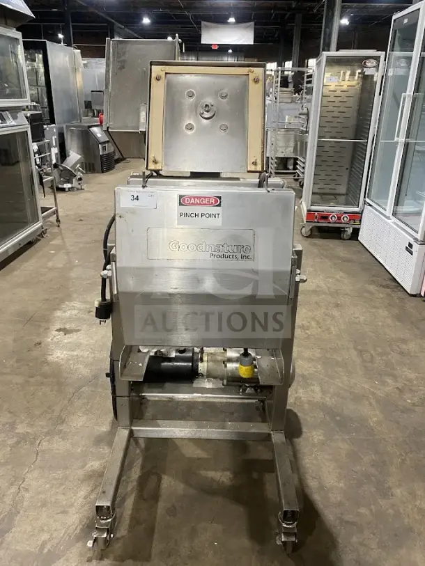 Goodnature commercial stainless steel hydraulic cold press juicer on casters, featuring clear "Danger" and brand labels.