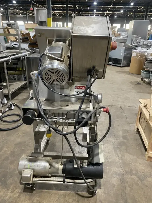 Goodnature commercial stainless steel hydraulic cold press juicer on casters; industrial design with visible safety labels.