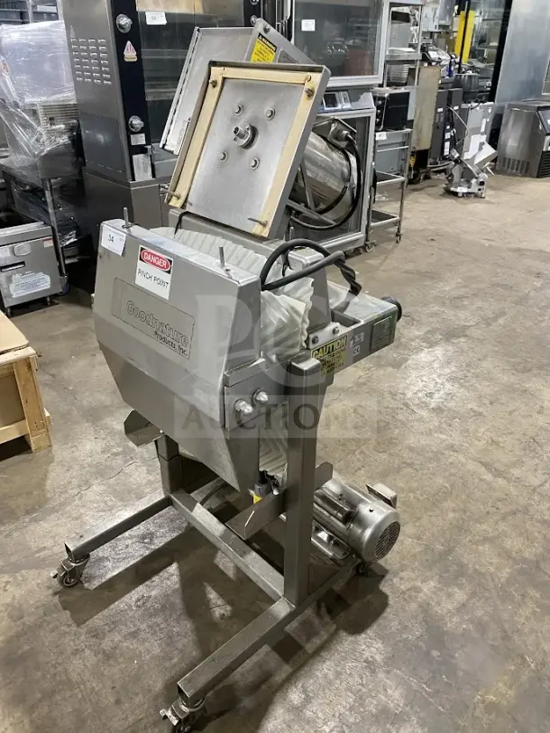 Goodnature commercial stainless steel hydraulic cold press juicer on casters, featuring caution and pinch point labels, in used condition.