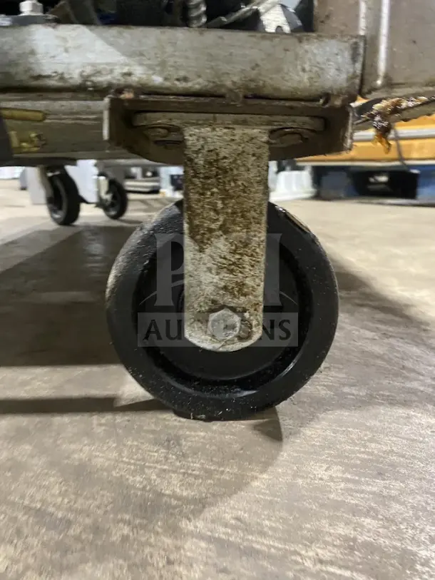 Goodnature Commercial Juicer caster wheel, showing signs of use, sturdy construction.