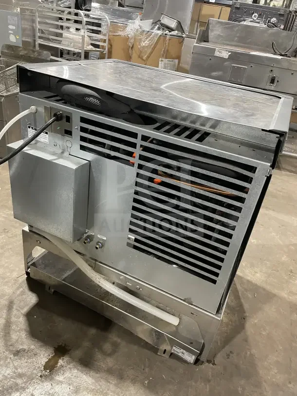 Follett stainless steel under-counter ice storage bin/dispenser base, commercial grade, good condition, visible hoses and vents.