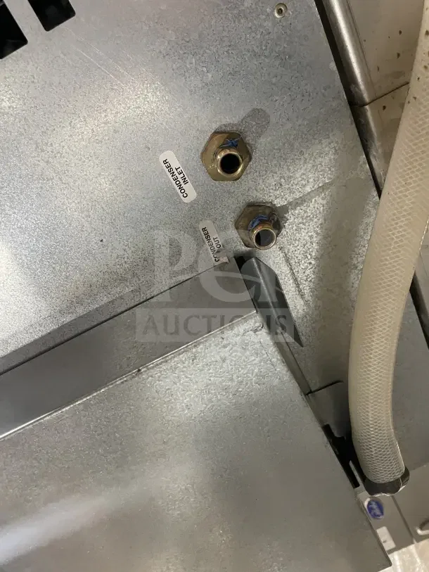 Follett stainless steel under-counter ice storage bin and dispenser base, showing condenser inlet/outlet labels.