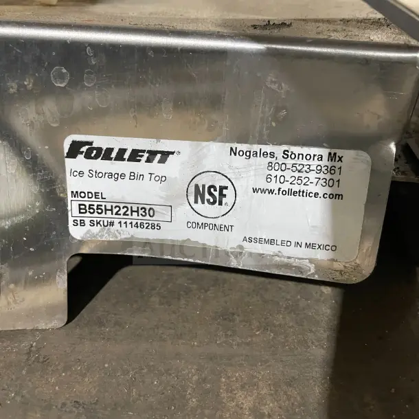 Follett commercial stainless steel under-counter ice storage bin, model B55H22H30, tag shows NSF certification and assembly in Mexico.