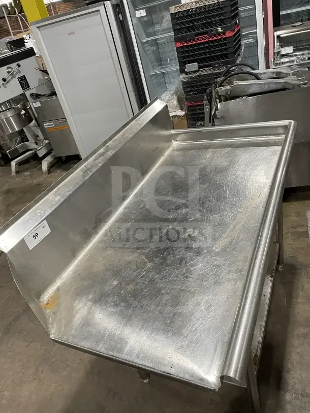 Commercial stainless steel soiled dishtable with backsplash. Features casters for mobility. Shows minor wear, tag marked "59."
