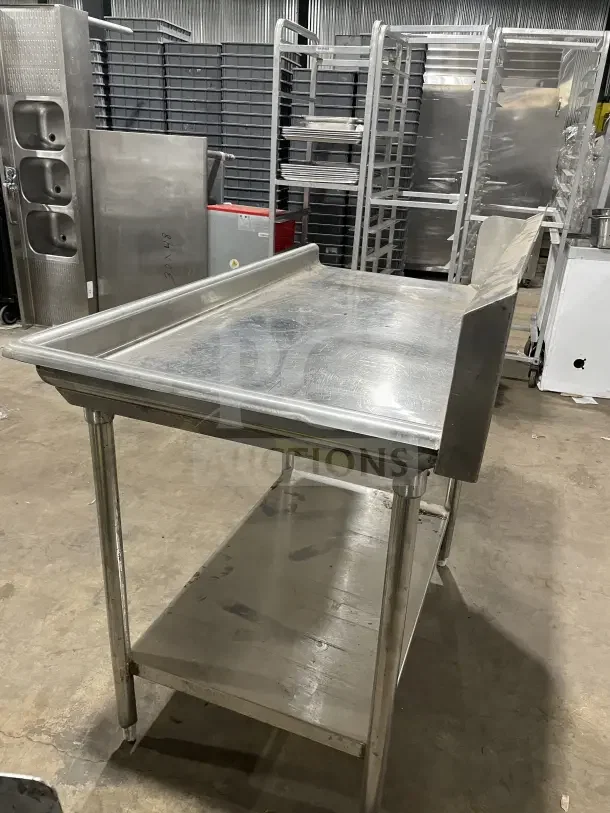 Commercial stainless steel soiled dish table with backsplash, on casters. Features sturdy design and lower shelf for storage.