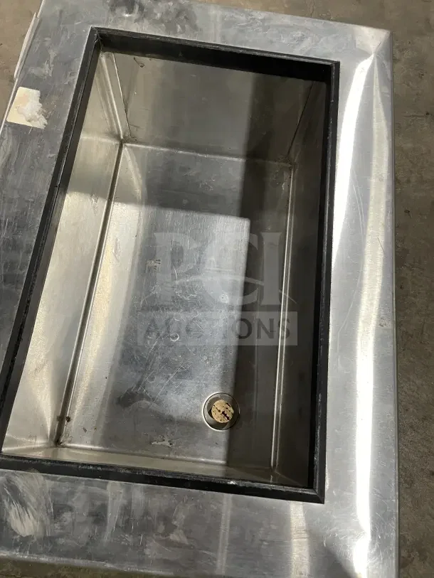 SupremeMetal DICP-1 stainless steel drop-in cold food well, shows drain plug, good condition, ideal for commercial use.