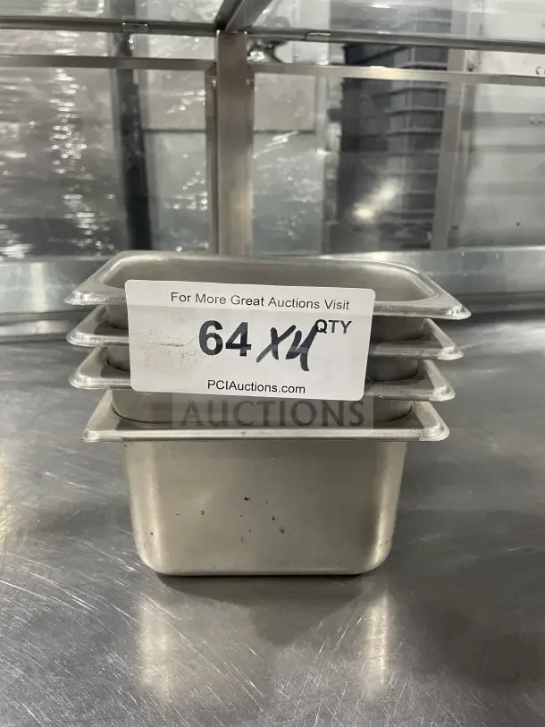 Winco SPN4 stainless steel half-size steam table pan stack in used condition with auction tag visible.