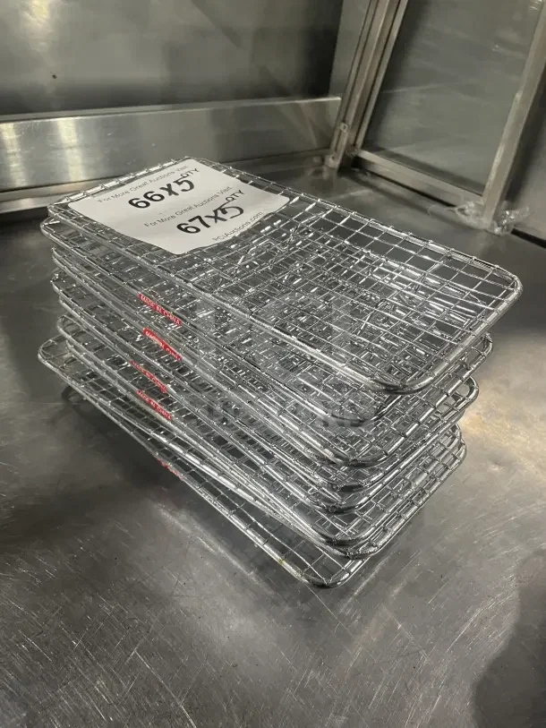 Vollrath stainless steel 1/3 size wire pan grate, stack of five, commercial quality, shown on metal surface, labels visible.