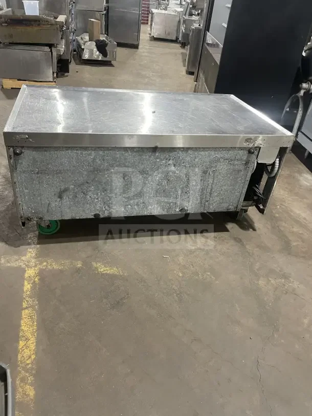 Commercial stainless steel refrigerated chef base with single door, 2 drawers, on casters, industrial setting.