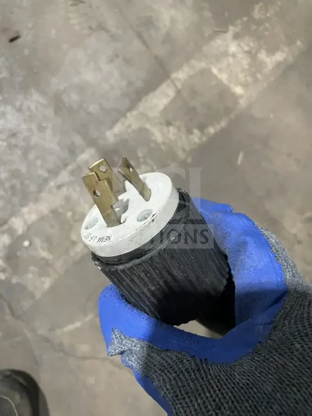 Gloved hand holding an electrical plug compatible with the Alto-Shaam HSM485S food merchandiser.