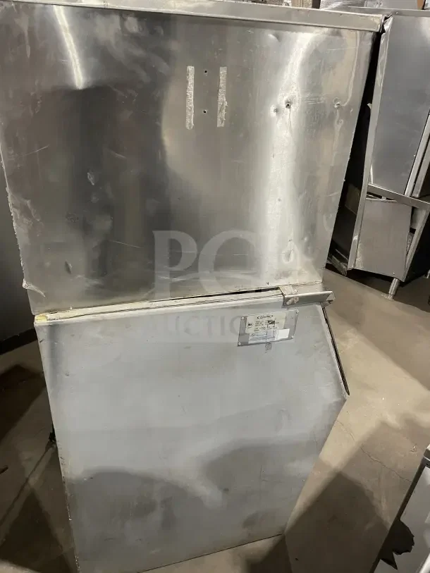Hoshizaki stainless steel air-cooled modular ice machine with storage bin, visible surface wear, label attached.