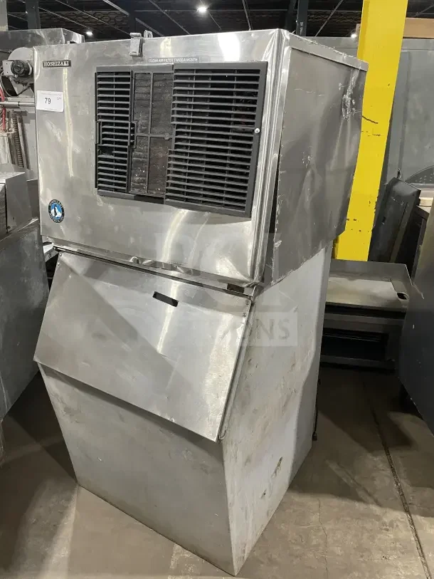 Hoshizaki commercial stainless steel air-cooled modular ice machine with storage bin. Features visible dents and wear.