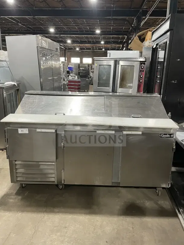 Leader LM72 stainless steel 3-door refrigerated prep table with casters; includes poly-coated wire rack; serial: PQ012493.