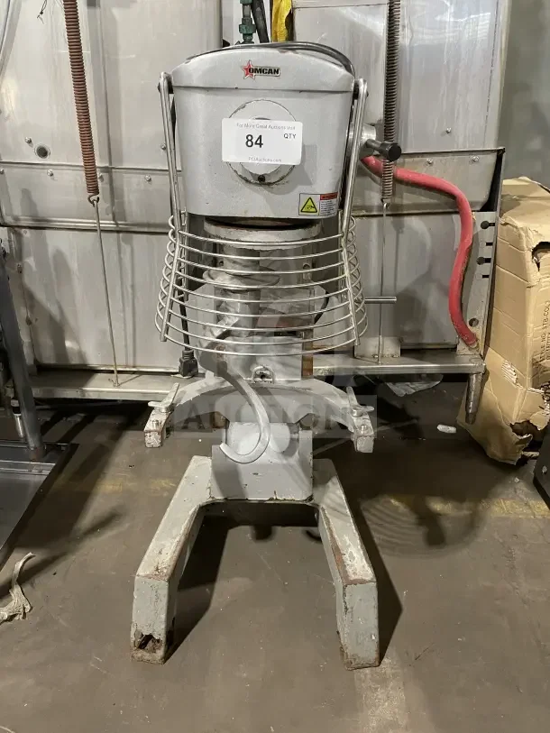 Omcan commercial 30-quart planetary floor mixer, gray, used condition. Features protective guard and visible brand logo.